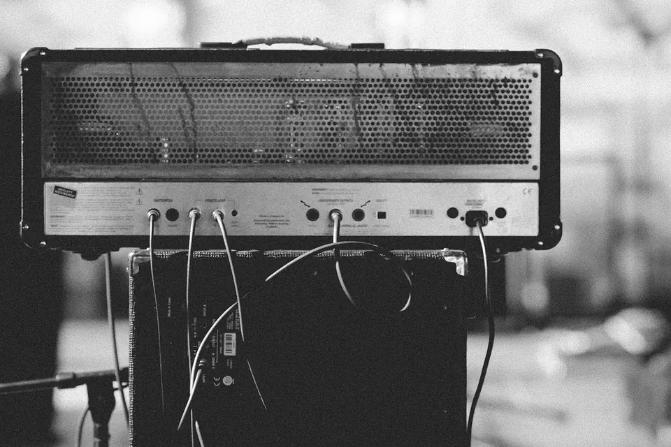 Ampli de guitare vintage vu de près en noir et blanc, grille et boutons de réglage