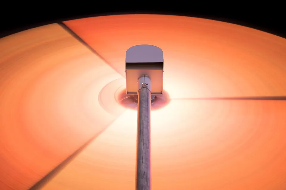 Disque vinyle orange sur une platine, avec le bras et la pointe de lecture posés sur le sillon